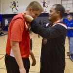 man awarding a medal to a basketball player
