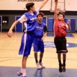 basketball players jumping to block a shot