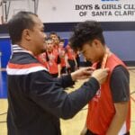 red team basketball player receiving a medal