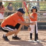 coach fixing the stance of a batter