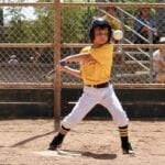 kid with yellow jersey about to hit a ball