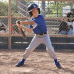 kid in blue uniform raising a bat