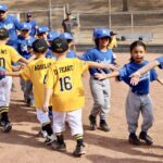 blue and yellow baseball teams high fiving