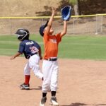 boy in orange uniform catching a ball