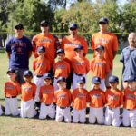 baseball team in orange uniform posing for a picture