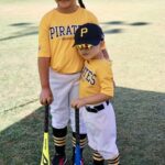 two kids in yellow uniforms posing for a picture
