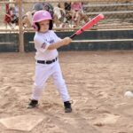 kid with pink helmet and bat