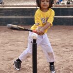 girl practicing how to hit a ball with a bat