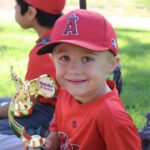 kid with trophy smiling for a picture